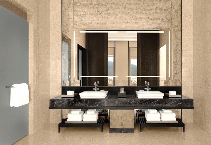 Chiang Mai Marriott Hotel's luxury bathroom with double vanity sinks, marble countertop, and illuminated mirror. Best wellness hotel for gay travelers.