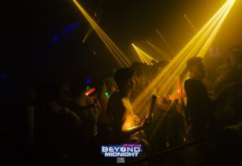 London's Beyond Club after-hours party. Go-go boys and men dance under yellow lights. Gay nightlife at Fire London club.