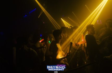 London's Beyond Club after-hours party. Go-go boys and men dance under yellow lights. Gay nightlife at Fire London club.