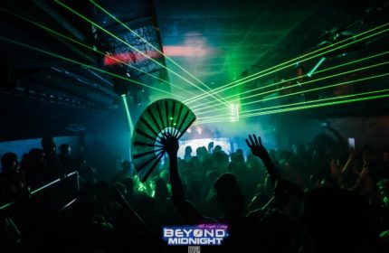 Beyond Club, London's gay dance club in Vauxhall. Crowd partying under green laser lights, one person holding a fan. Fire London.