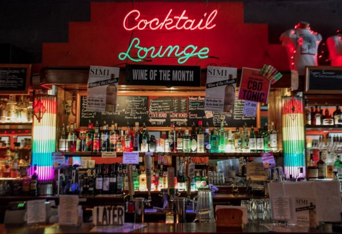 Chicago gay bar, Big Chicks interior. Cocktail lounge with neon sign, fully stocked bar, wine of the month, and chalkboard menu. Fetish-friendly.