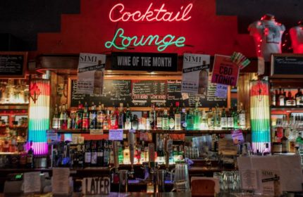 Chicago gay bar, Big Chicks interior. Cocktail lounge with neon sign, fully stocked bar, wine of the month, and chalkboard menu. Fetish-friendly.