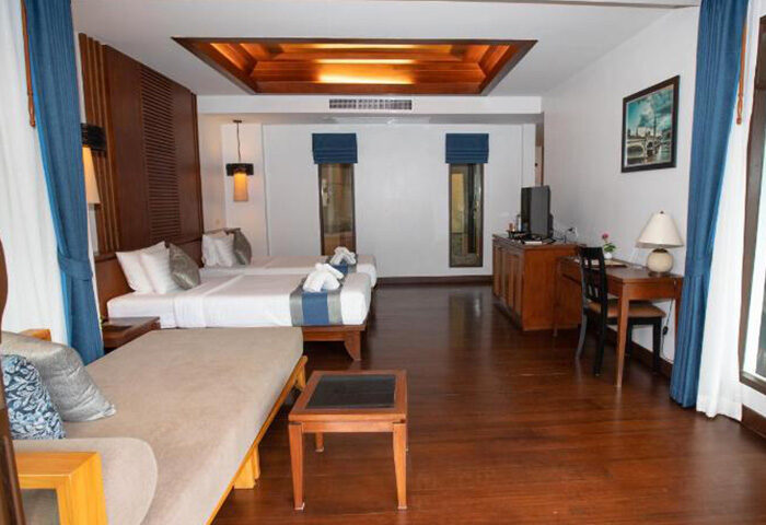 Railay Village Resort big room, cheap price. Gay hotel in Krabi, Thailand. Two beds, desk, couch, and wooden floors.