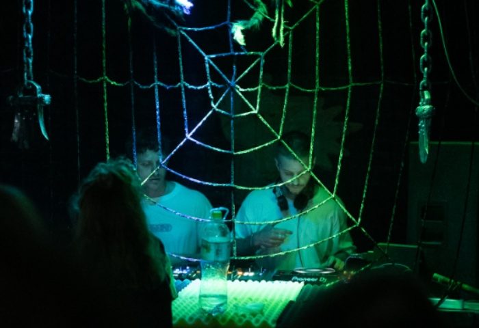 BirdCage Club Hanoi: DJs perform at the gay bar, with a spiderweb decoration and green lighting, for gay men travel advice.