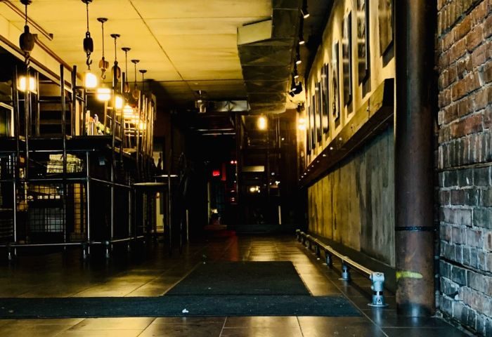 Interior of Black Eagle cruising bar in Toronto. Dim lighting, industrial design, bar stools, and exposed brick. Gay travel advice.