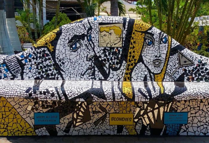 Mosaic bench art at Blondies Loft Slush Bar, a gay party spot in Puerto Vallarta. Features portraits & Blondies name. Gay travel.