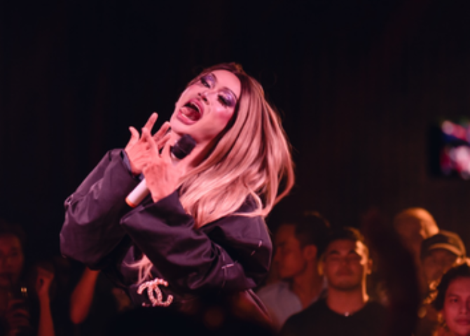 Drag queen at Blue Chilli, Phnom Penh. Gay travel advice: performer with blonde hair, purple eyeshadow, singing into a microphone. Nightlife.