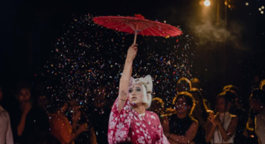 Drag queen with red umbrella in Phnom Penh, Cambodia. Gay travel destination with vibrant nightlife and culture. Blue Chilli bar scene.
