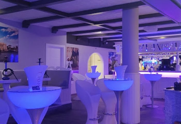 Blue Havana Lounge, a gay bar in Gran Canaria. Interior view with illuminated tables and chairs, creating a vibrant atmosphere for gay travelers.