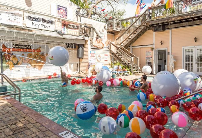 Bourbon St. Pub gay bar in Key West. Men in pool with beach balls. Live music venue with outdoor area. Gay travel destination.