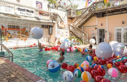 Bourbon St. Pub gay bar in Key West. Men in pool with beach balls. Live music venue with outdoor area. Gay travel destination.