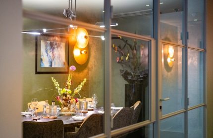 Boutique Hotel Albus Amsterdam Centre dining room. View through glass doors. Best gay hotel Amsterdam, stylish interior, table setting.