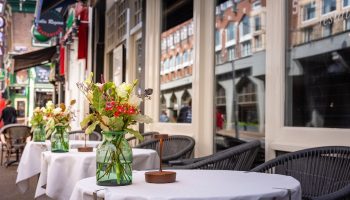 Boutique Hotel Albus Amsterdam Centre outdoor seating. Gay-friendly hotel with tables, flowers, and city views. Most booked hotel.