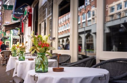 Boutique Hotel Albus Amsterdam Centre outdoor seating. Gay-friendly hotel with tables, flowers, and city views. Most booked hotel.