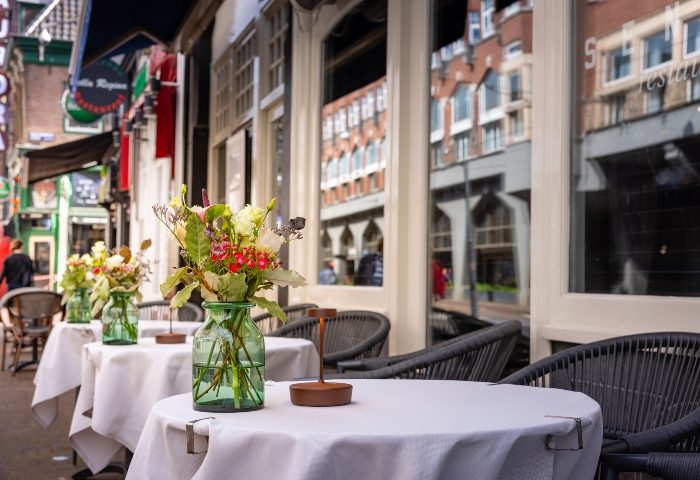Boutique Hotel Albus Amsterdam Centre outdoor seating. Gay-friendly hotel with tables, flowers, and city views. Most booked hotel.