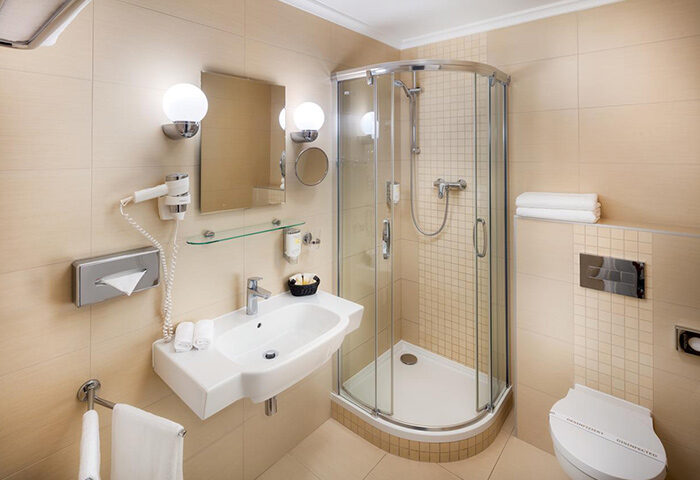 Bathroom at Boutique Hotel Seven Days, Prague. Popular gay hotel in Vinohrady, featuring a shower, sink, and toilet. Clean design.