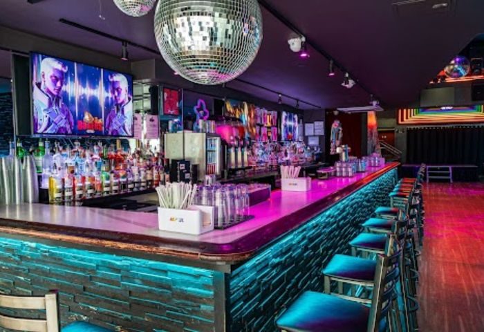 Boxers NYC: Interior of the gay bar in New York City. Disco ball, bar stools, liquor bottles, and TVs create a vibrant atmosphere.