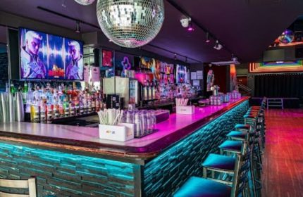 Boxers NYC: Interior of the gay bar in New York City. Disco ball, bar stools, liquor bottles, and TVs create a vibrant atmosphere.