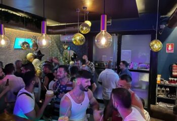Boys Bar Barcelona: A lively gay bar scene in Barcelona. Men socialize under stylish lighting, enjoying drinks and the vibrant atmosphere. Gay travel hotspot.