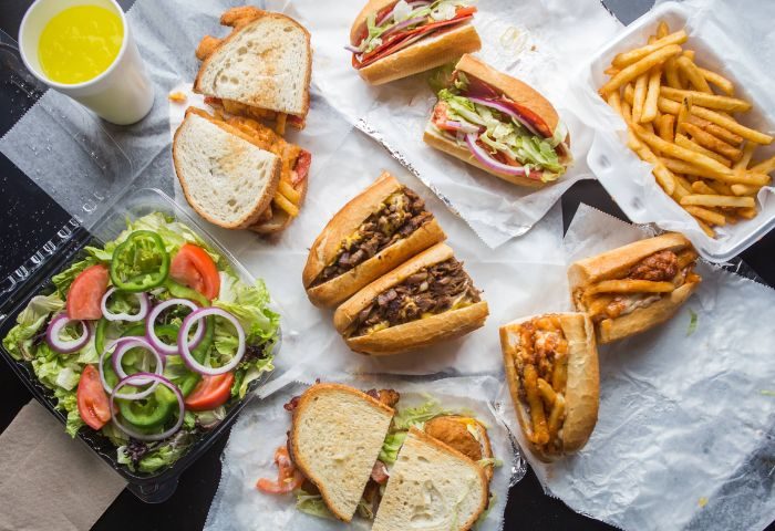 NYC Branded Saloon food: sandwiches, salad, fries, and a drink. A delicious spread at this popular gay-friendly New York spot.