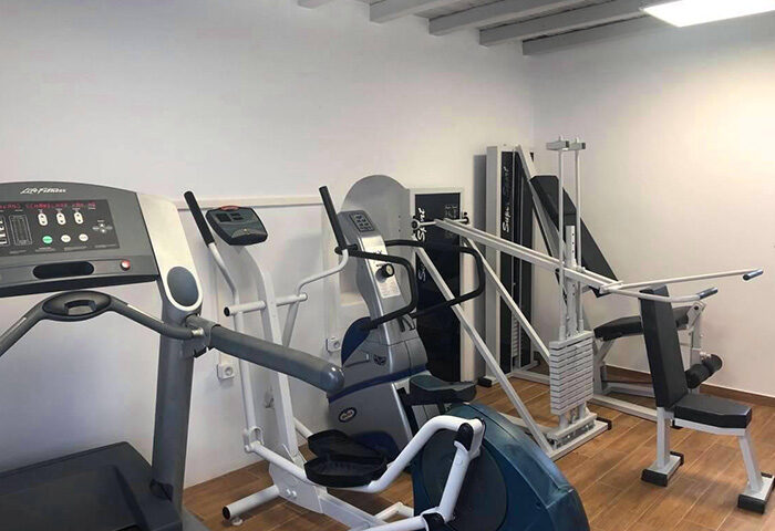 Elena Hotel gym in Mykonos Town. Budget gay hotel with gym equipment including treadmill, elliptical, and weight machine.