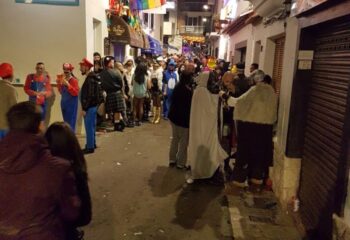 Gay Cruise Club in Sitges street party. Revelers in costume gather for a Bukkake Cruise Club event. Festive nightlife scene.