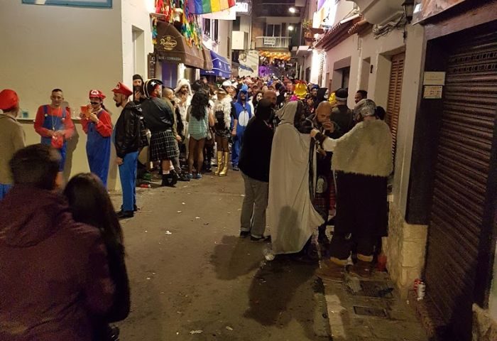 Gay Cruise Club in Sitges street party. Revelers in costume gather for a Bukkake Cruise Club event. Festive nightlife scene.