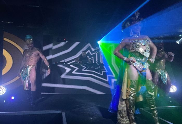 CENTURYON Gay Club in Torremolinos: Male dancers in Egyptian-themed costumes perform on stage with a DJ in the background. Nightlife scene.