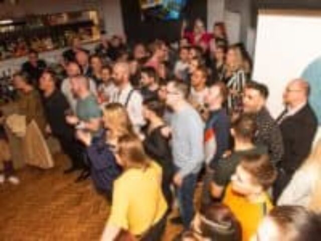 Packed CMYK Bar Wimbledon. A vibrant gay bar scene with a diverse crowd enjoying drinks and socializing. Popular gay nightlife destination.