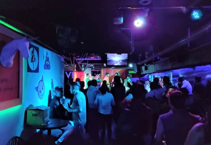 Cabaretito El Taller gay bar in Mexico. Interior view of a crowded gay bar with people dancing and socializing under colorful lights.