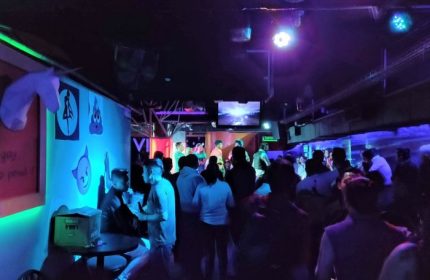 Cabaretito El Taller gay bar in Mexico. Interior view of a crowded gay bar with people dancing and socializing under colorful lights.