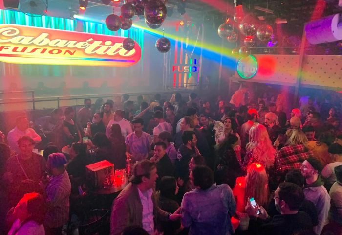 Cabaretito Fusion Gay Bar in Mexico: A crowded, lively gay bar scene with disco balls and colorful lights. Gay nightlife travel destination.