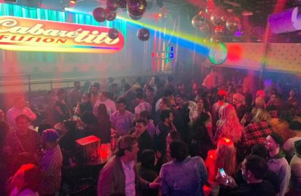 Cabaretito Fusion Gay Bar in Mexico: A crowded, lively gay bar scene with disco balls and colorful lights. Gay nightlife travel destination.