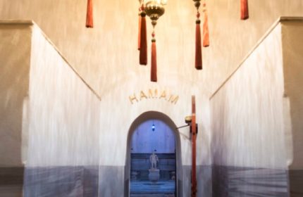 Cagaloglu Hamam entrance in Istanbul. Arched doorway to Turkish bath, with hanging lamps and 'Hamam' sign. Gay travel advice.