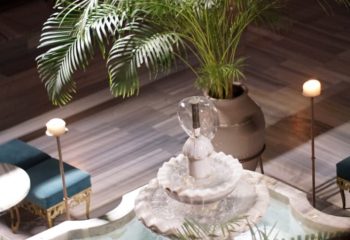 Cagaloglu Hamam Istanbul interior. Fountain, plants, candles, and seating create a relaxing spa atmosphere. Gay travel advice.