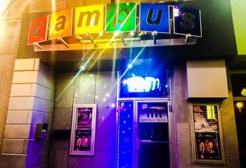 Campus gay strip bar in Montreal. Exterior shot of the bar's entrance with colorful Campus sign. Gay travel advice.