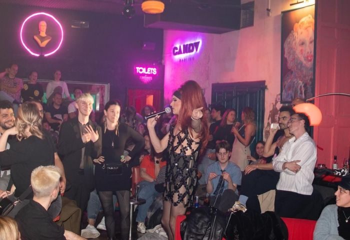 Drag queen performing at Candy Darling Gay Bar in Barcelona. Crowd of gay men enjoying the show in a vibrant atmosphere. Nightlife.