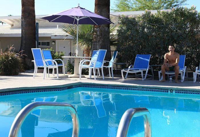 Canyon Club Hotel pool in Palm Springs. Gay accommodation with a man relaxing by the pool. Travel advice for gay men.
