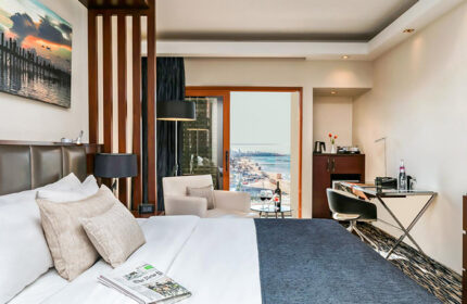 Carlton Tel Aviv Hotel luxury beachfront room. View of the beach. Gay hotel near gay bars and saunas. Wine, desk, and newspaper.
