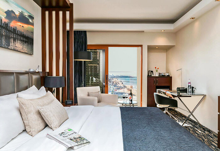 Carlton Tel Aviv Hotel luxury beachfront room. View of the beach. Gay hotel near gay bars and saunas. Wine, desk, and newspaper.