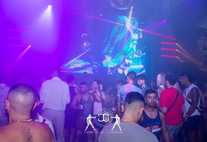 Slaughter's Night Club, a gay bar in Puerto Vallarta, Mexico. People dance under colorful lights and a disco ball in the gay nightlife scene.