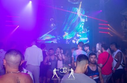 Slaughter's Night Club, a gay bar in Puerto Vallarta, Mexico. People dance under colorful lights and a disco ball in the gay nightlife scene.