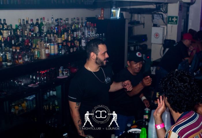 Inside CC Slaughters Nightclub, a popular gay bar in Puerto Vallarta. People are enjoying drinks at the bar. Nightlife scene.
