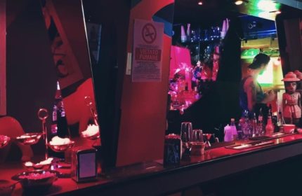 Rome club bar interior with bartender, Vietato Fumare sign, red lighting. Gay travel advice, nightlife scene. Censured Club Rome.