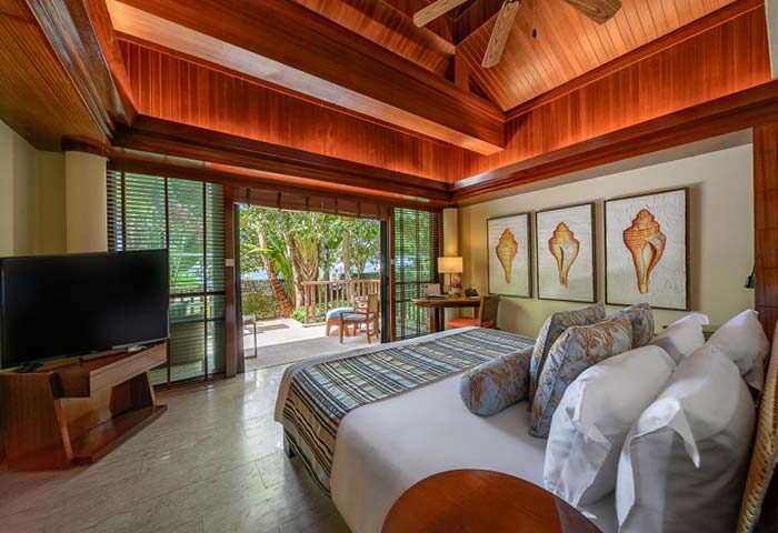 Centara Grand Beach Resort & Villas Krabi room. Gay travel: bedroom with balcony, TV, shell art. Luxury Krabi resort stay.