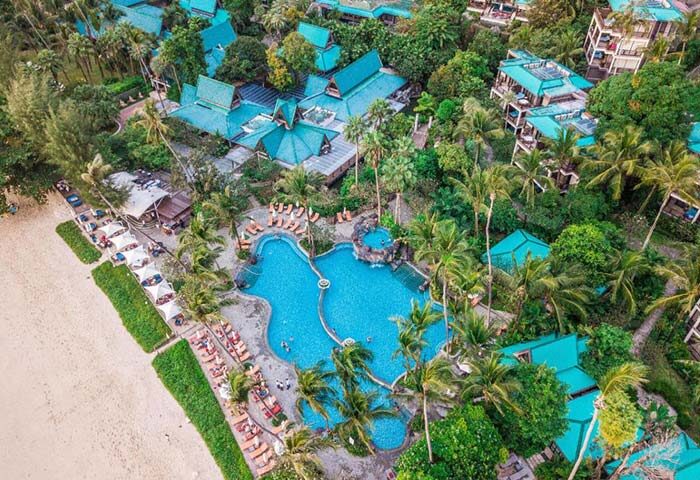 Aerial view of Centara Grand Beach Resort & Villas Krabi, a gay-friendly resort. Pool, beach, lush greenery, & Thai architecture visible.