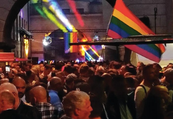 Centralhjornet Copenhagen gay bar crowd with rainbow flags and disco ball. Gay men travel advice in Denmark's capital.