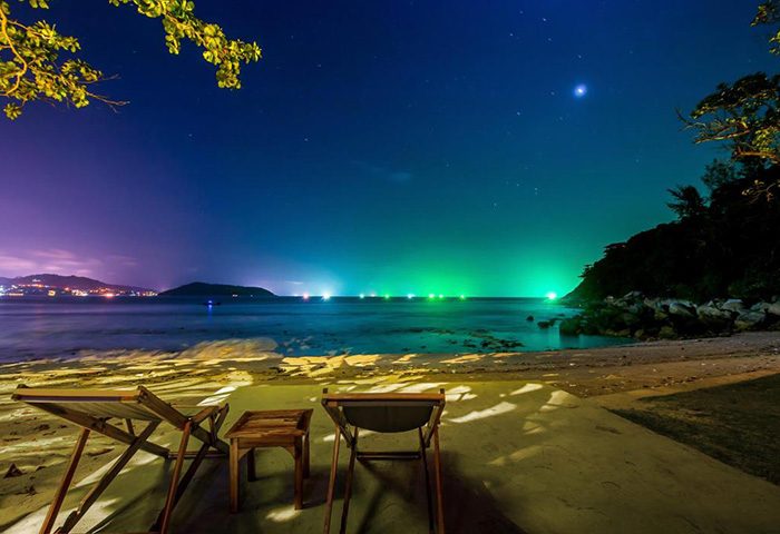 The Naka Phuket Villa beach at night. Private pool villa, quiet and private, gay hotel in Phuket. Beach chairs under a starry sky.