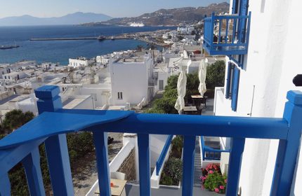 Mykonos Town's Portobello Boutique Hotel view. Balcony of this cheap 3-stars gay hotel overlooks the Aegean Sea and whitewashed buildings.