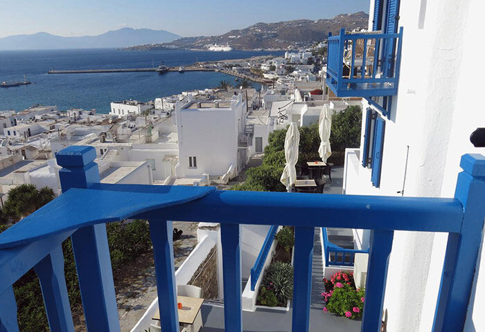 Mykonos Town's Portobello Boutique Hotel view. Balcony of this cheap 3-stars gay hotel overlooks the Aegean Sea and whitewashed buildings.